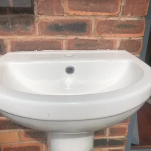 Two white toilets and a white hand basin - Image 6