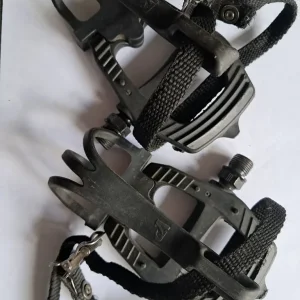 Pair of black bike pedals, toe caged with straps