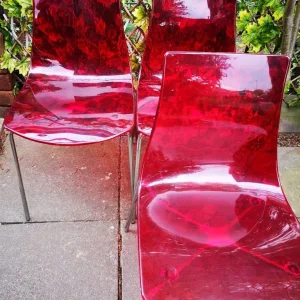 Three red plastic chairs