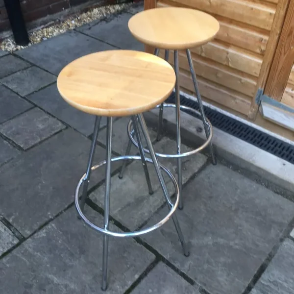 Two identical tubular metal framed stools with round wooden seats