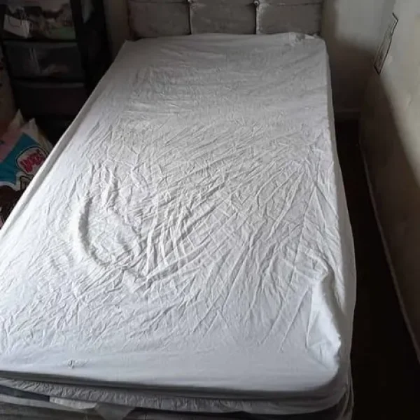 Grey fabric single bed with headboard