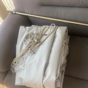 Beige curtains, brass gold curtain pole and tie backs