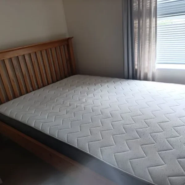 Double bed with solid brown wood frame