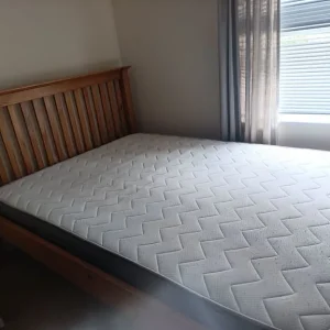 Double bed with solid brown wood frame