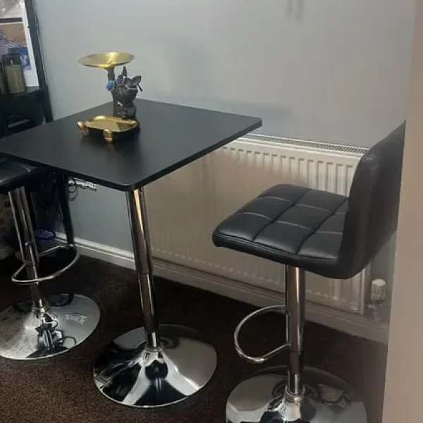 Two black bar stools with chrome bases