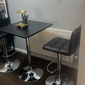 Two black bar stools with chrome bases