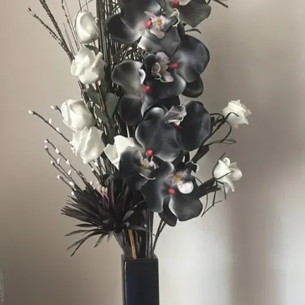 Black and white fake orchids in black vase