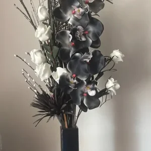Black and white fake orchids in black vase
