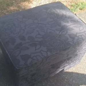 Black storage footstool with built-in compartments