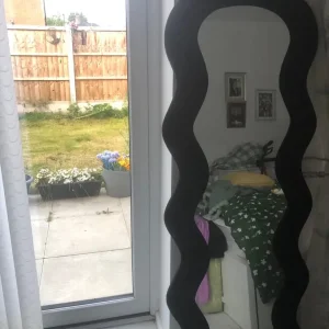 Modern curvy black velvet mirror