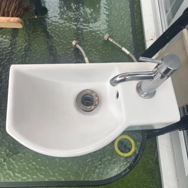 Cloakroom sink with chrome tap and hoses