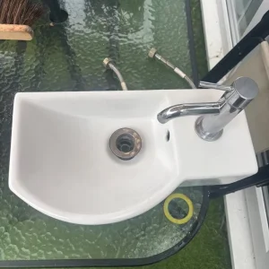 Cloakroom sink with chrome tap and hoses