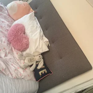 Grey double bed with built-in TV and storage