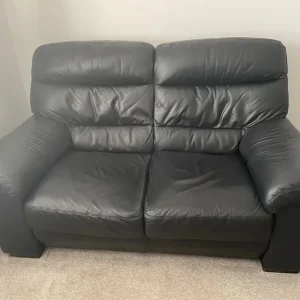Black leather 2 seater sofa x2 with matching footstool